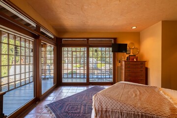 Sticker - Cozy bedroom interior with a bed, large wooden windows, and a bright light coming in