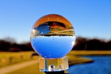 Glass Ball On A Stand With The Reflection Of A Golden Field And Blue Sky
