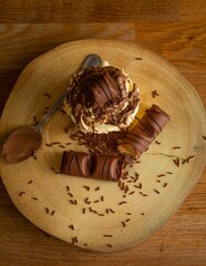Wall Mural - Top view of a creamy chocolate dessert on a wooden plate with a spoon