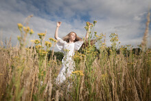 Summer Portrait Of Woman In White Dress Dancing In The Field