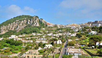 Wall Mural - Cityscape of Capri, Italy. Residential buildings, roads, a lot of greenery. Hills in the distance