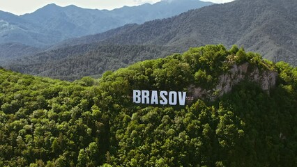 Wall Mural - Brasov sign on the top of the hill near the city, green trees, tourists, Romania