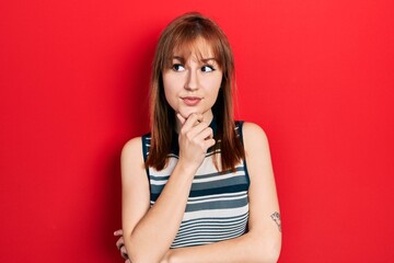 Poster - Redhead young woman wearing casual t shirt with hand on chin thinking about question, pensive expression. smiling with thoughtful face. doubt concept.