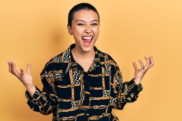 Canvas Print - Beautiful hispanic woman with short hair wearing elegant shirt crazy and mad shouting and yelling with aggressive expression and arms raised. frustration concept.