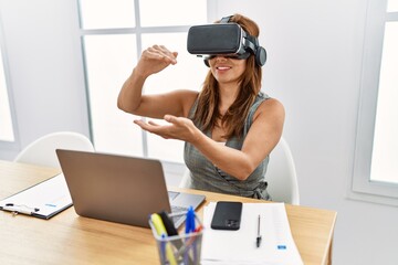 Young latin woman business worker using laptop and vr goggles at office