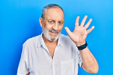 Wall Mural - Handsome senior man with beard wearing casual white shirt showing and pointing up with fingers number five while smiling confident and happy.