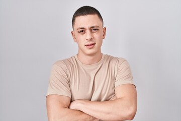 Canvas Print - Young man standing over isolated background skeptic and nervous, disapproving expression on face with crossed arms. negative person.