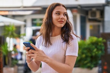 Poster - Young woman smiling confident using smartphone at street