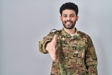 Sticker - Arab man wearing camouflage army uniform smiling friendly offering handshake as greeting and welcoming. successful business.