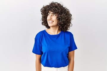 Wall Mural - Young middle eastern woman standing over isolated background smiling looking to the side and staring away thinking.