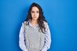 © Krakenimages.com - Young brunette woman standing over blue background depressed and worry for distress, crying angry and afraid. sad expression.