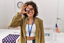 Young Hispanic Woman Smiling Confident Holding I Voted Badge Over Eye At Electoral College