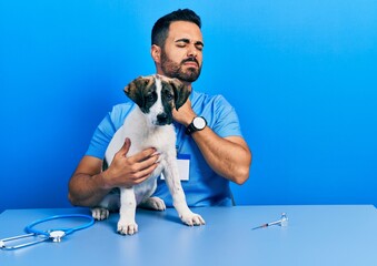 Canvas Print - Handsome hispanic veterinary man with beard checking dog health touching painful neck, sore throat for flu, clod and infection