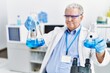 © Krakenimages.com - Middle age grey-haired man wearing scientist uniform holding test tube at laboratory