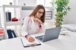 © Krakenimages.com - Young woman wearing doctor uniform writing on clipboard working at clinic