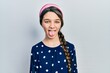 Young brunette girl wearing elegant look sticking tongue out happy with funny expression. emotion concept.