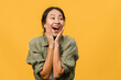 © tirachard - Young Asia lady feel happiness with positive expression, joyful surprise funky, dressed in casual cloth isolated on yellow background. Happy adorable glad woman rejoices success. Facial expression.