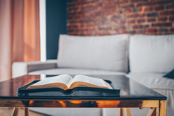 Wall Mural - Open bible on table in living room, modern interior