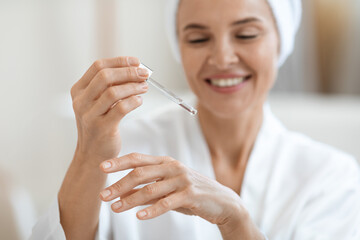 Wall Mural - Cheerful woman testing newest beauty product on her hand