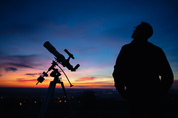 Wall Mural - silhouette of a man, telescope and countryside under the starry
