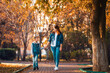 Young mother and son holding hands and walking together in the autumn park. The concept of happy family