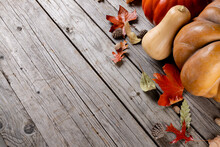 Composition Of Pumpkins With Pinecones And Autumn Leaves On Wooden Background