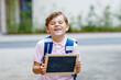 Happy little kid boy with backpack or satchel. Schoolkid on the way to school. Healthy adorable child outdoors On desk Last day second grade in German. School's out