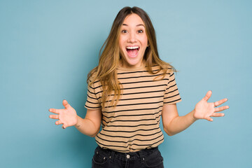 Wall Mural - Excited woman with mouth open in a studio