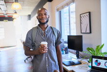 A Black Trendy Man Arrives At The Office With His Coffee And Backpack