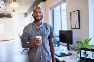 Wall Mural - A Black trendy man arrives at the office with his coffee and backpack