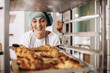 © Petro - Female baker at the kitchen holding croissant