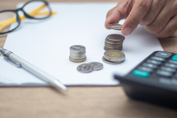 Hand holding a coin on a pile of business people concept