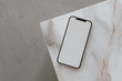 Aesthetic chic online store, online shopping, blog, social media branding composition. Mobile phone with blank copy space screen on marble side table. Neutral colors template