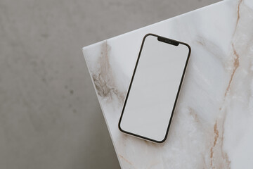 Aesthetic chic online store, online shopping, blog, social media branding composition. Mobile phone with blank copy space screen on marble side table. Neutral colors template