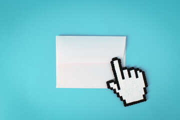 Minimal concept envelope and hand finger cursor on blue background. Flat lay.