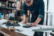 © Charnchai saeheng - Engineering working with drawings inspection on the office desk and Calculator, triangle ruler, safety glasses, compass, vernier caliper on Blueprint.