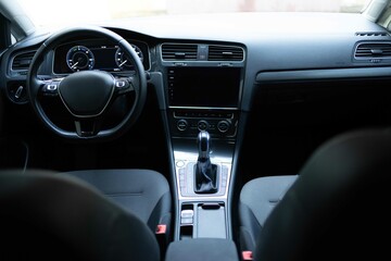 Electric car interior details adjustments. Inside car interior with front seats, driver and passenger, textile, windows, console, gear shift, electric buttons, digital speedometer