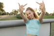 Hispanic young woman in sportswear showing the middle finger making fuck you bad expression, provocation and rude attitude. screaming excited, outdoors