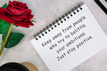 Wall Mural - Motivational quote on a note book with roses on a desk.