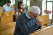 © pressmaster - Mature man inclining his head and bending over his hands put together during silent pray after sermon or before communion in church