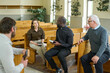 © pressmaster - Young African American priest with Bible talking to one of parishioners while explaining her some verses from New Testament