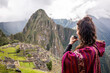Woman Looking at Inca Citadel called Machupichu built of stones on the mountain, cloudy day, Peru