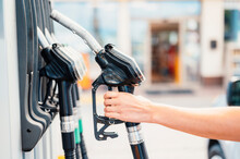 Closeup Of Woman Pumping Gasoline Fuel In Car At Gas Station. Petrol Or Gasoline Being Pumped Into A Motor. Transport Concept