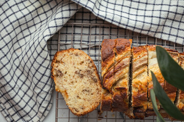 Wall Mural - Fresh banana bread on the white background. Homemade pastry on the checkered cloth. Flat lay