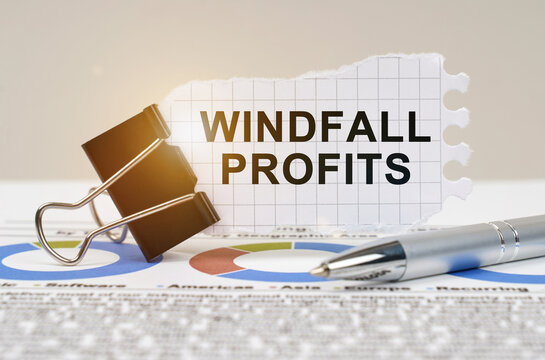 On the table are reporting charts, a pen, in a clip paper with the inscription - Windfall profits