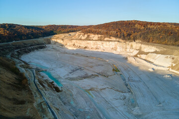 Wall Mural - Aerial view of open pit mine of sandstone materials for construction industry with excavators and dump trucks. Heavy equipment in mining and production of useful minerals concept