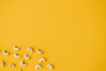 Wall Mural - Cashew nuts isolated on yellow background