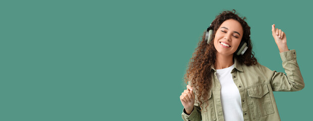 Poster - Young African-American woman listening to music and dancing on green background with space for text