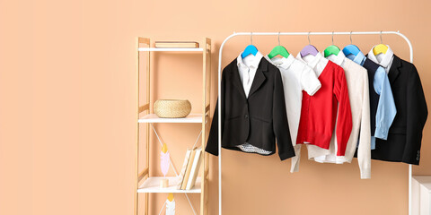 Wall Mural - Shelf unit and rack with school uniform near color wall