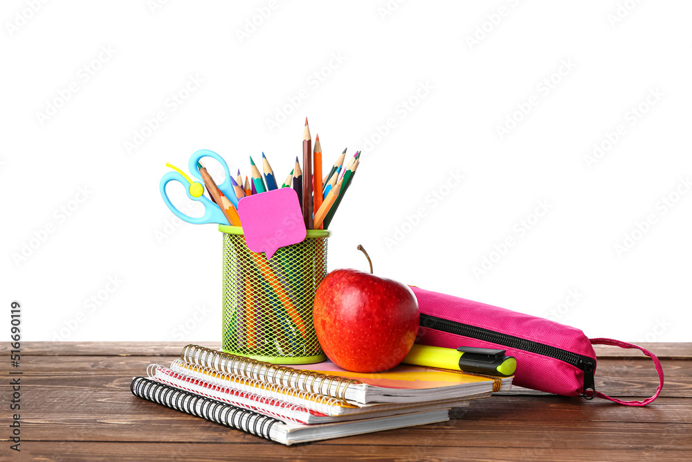 School stationery with apple on wooden table against white background